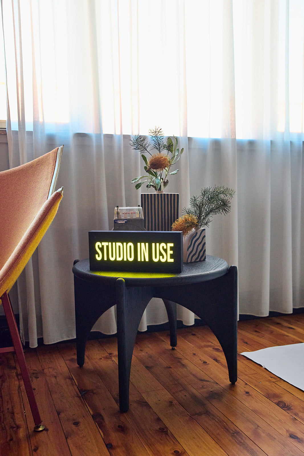 Studio-in-use sign on a side table at the Goodspace Kingsgrove product photography studio in Sydney