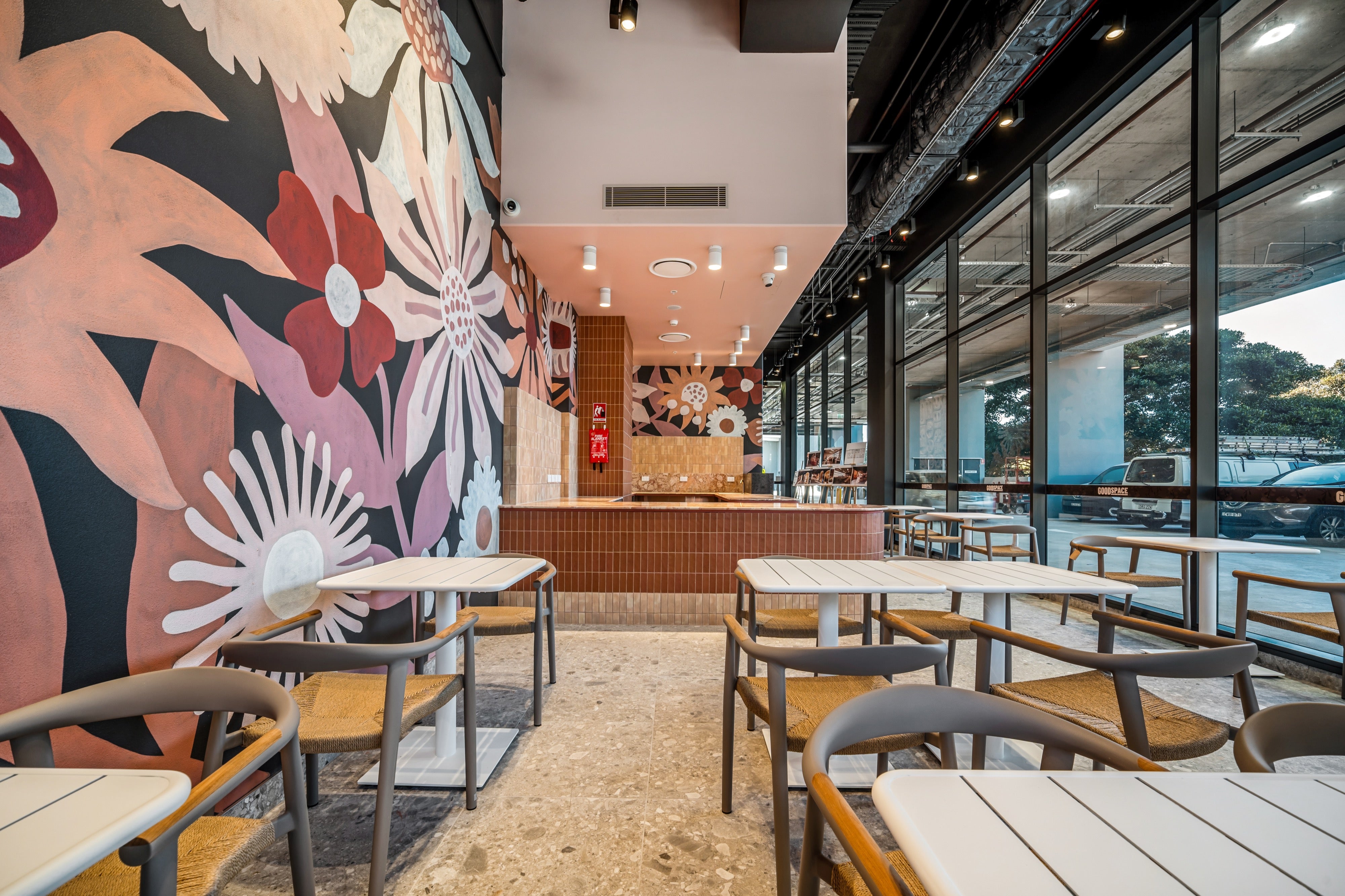 On-site café with floral mural and timber seating at Goodspace Eastgardens